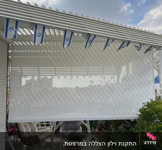 סוכך לבן עם דגלי ישראל על מרפסת